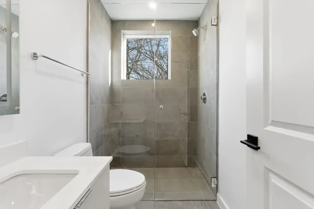 a bathroom with a toilet a sink and shower