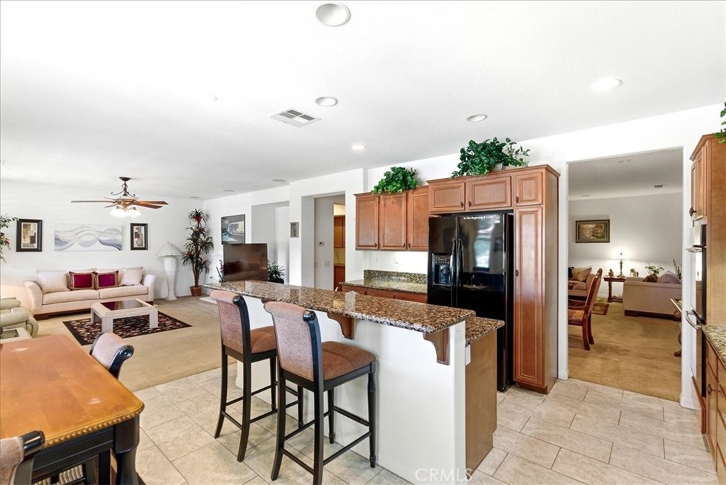 17715 Timberview Drive Riverside, CA 92504 - Photo 10 of 46 a kitchen with stainless steel appliances kitchen island granite countertop a refrigerator and stove