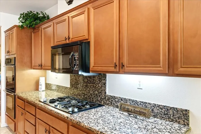 a kitchen with stainless steel appliances granite countertop a stove and a microwave
