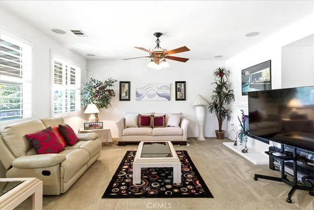a living room with furniture a flat screen tv and a large window