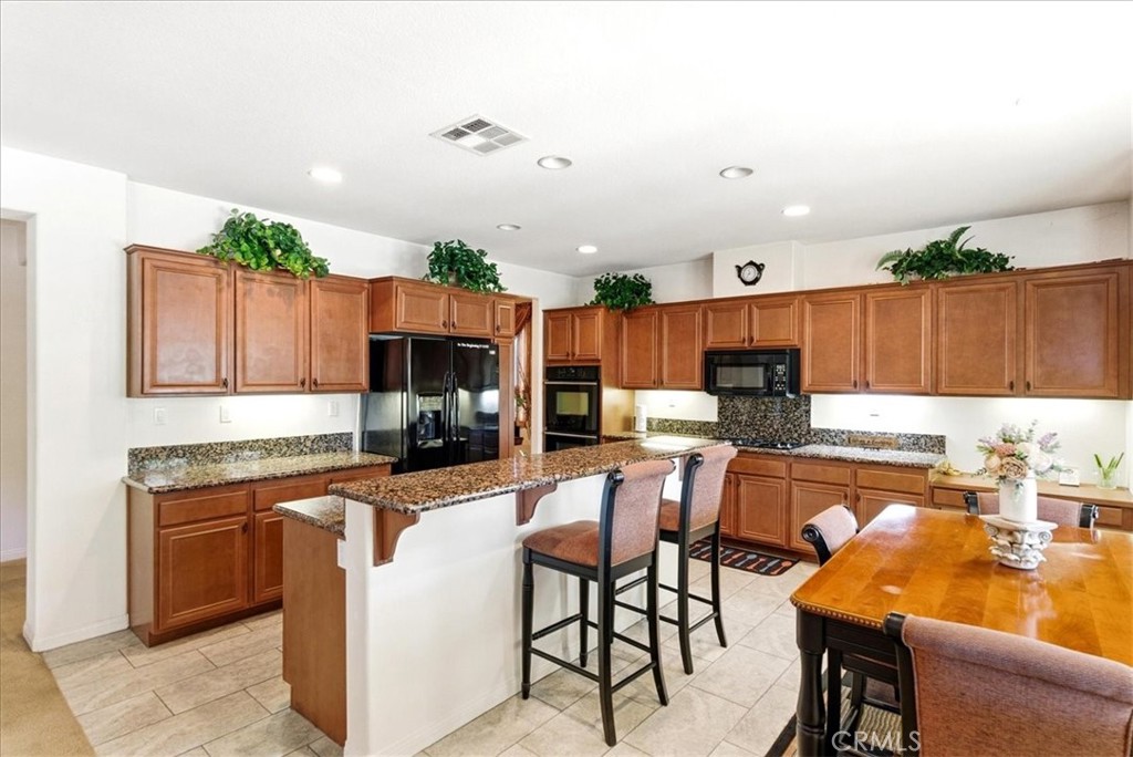 17715 Timberview Drive Riverside, CA 92504 - Photo 9 of 46 a kitchen with kitchen island granite countertop a table chairs sink and cabinets