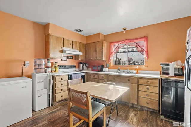 a kitchen with a table chairs refrigerator and cabinets