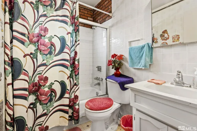 a bathroom with a sink toilet and shower curtain