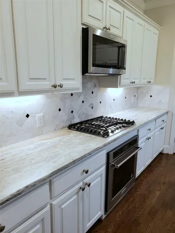 a kitchen with granite countertop a stove and a microwave