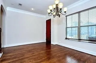 a view of a room with wooden floor and chandelier