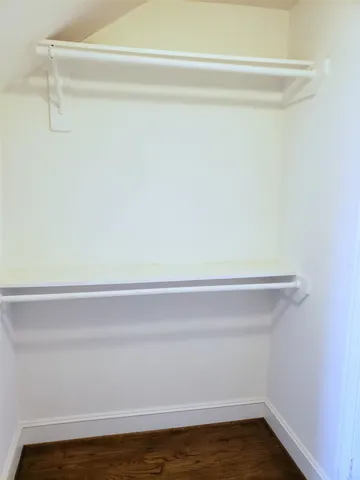 a view of walk in closet with empty racks