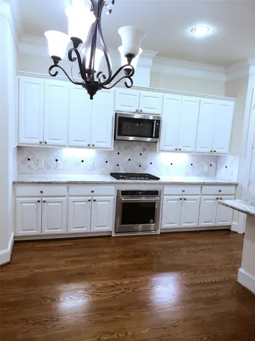 a kitchen with kitchen island granite countertop a sink cabinets and stainless steel appliances