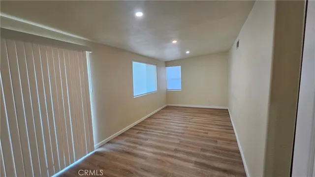 a view of empty room with wooden floor
