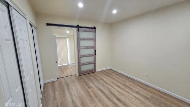 an empty room with wooden floor and sliding door