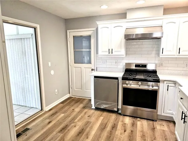 a kitchen with granite countertop a stove and a refrigerator