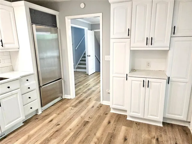 view of a kitchen with white cabinets and wooden floor