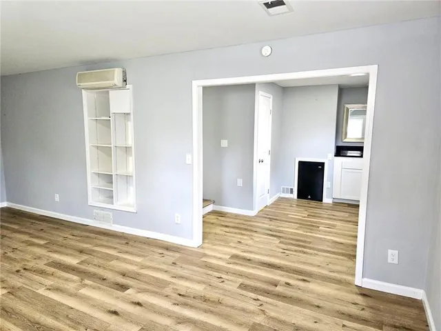 a view of empty room with wooden floor and entryway