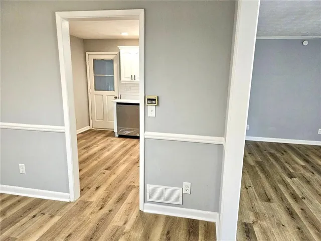 a view of a hallway with wooden floor and a living room