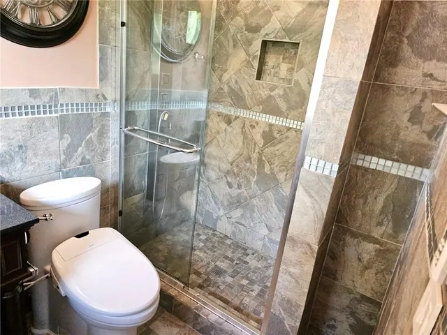 a bathroom with a toilet and a shower