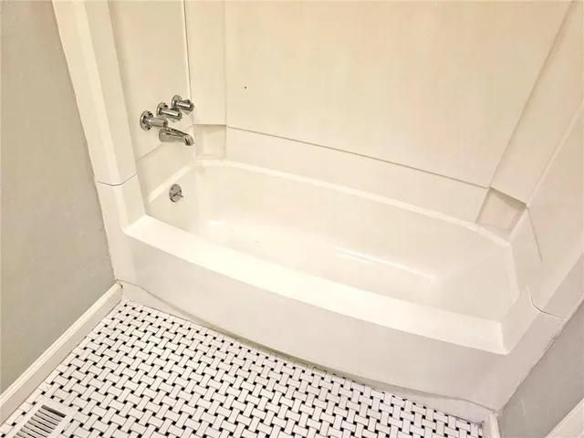 a view of a house with a large window and flower plants