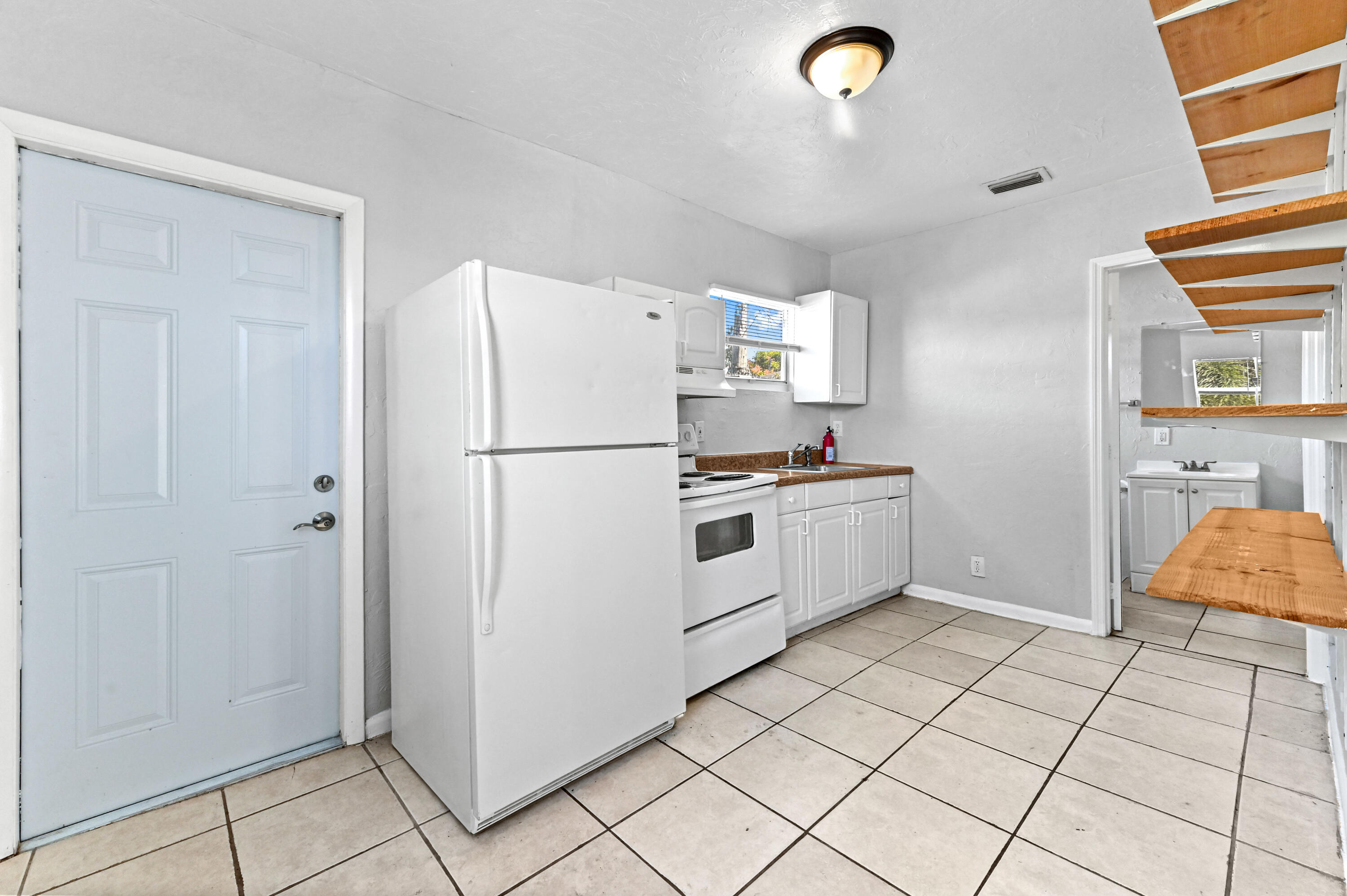 515 Putnam Road West Palm Beach, FL 33405 - Photo 13 of 23 a kitchen with granite countertop a refrigerator and a stove top oven