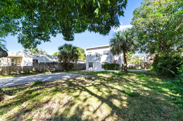 a view of a yard with plants and trees