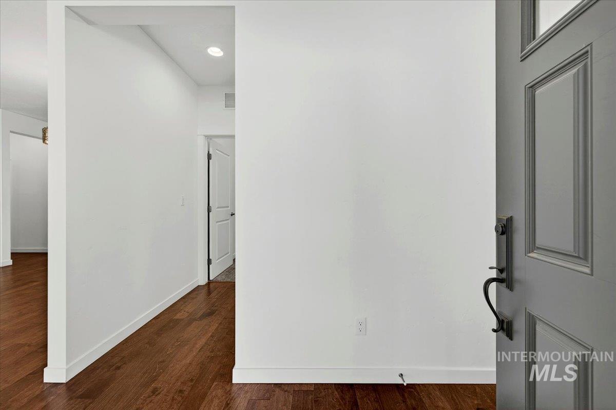4204 East Silverking Lane Meridian, ID 83642 - Photo 6 of 40 Entryway featuring a paneled door with matte black hardware, wood-finish flooring, and recessed lighting