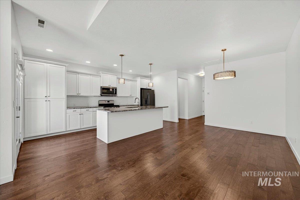 4204 East Silverking Lane Meridian, ID 83642 - Photo 10 of 40 Open-concept kitchen and dining area with wood-finish flooring