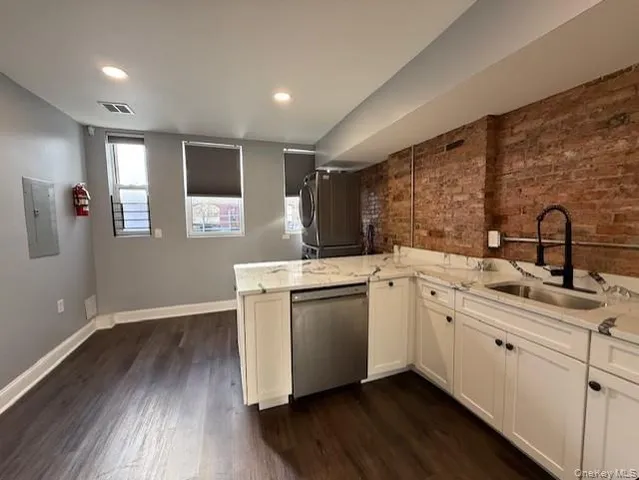 a kitchen with a sink cabinets and wooden floor