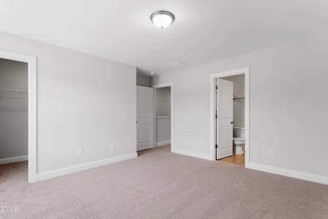 an empty room with closet and windows