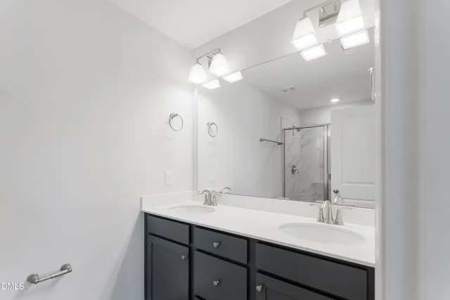 a bathroom with a double vanity sink and a mirror