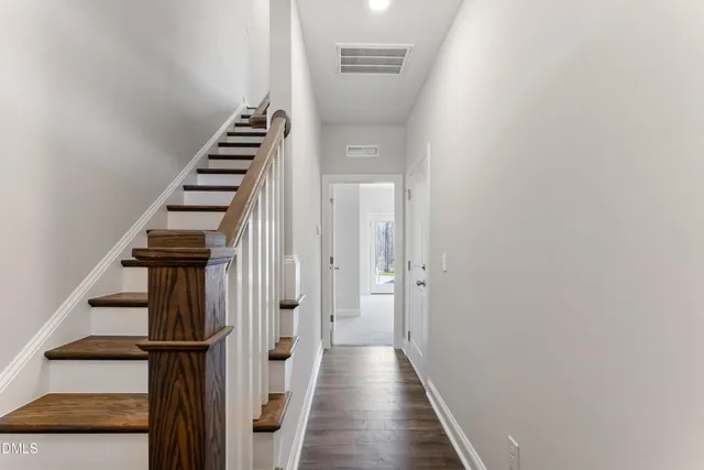 a view of a hallway with wooden floor and entryway