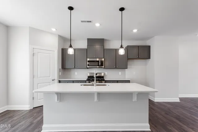 a kitchen with kitchen island a counter top space a sink and a chandelier