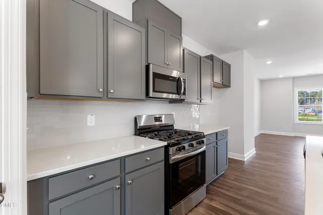 a kitchen with stainless steel appliances granite countertop a stove a sink and a microwave