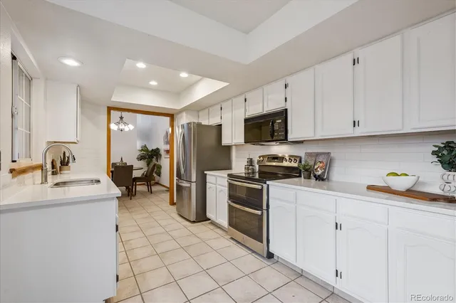 a kitchen with appliances a sink and cabinets