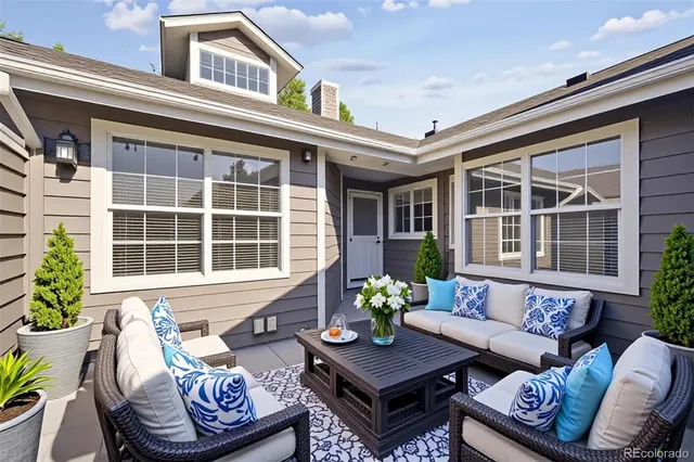 a view of a patio with couches table and chairs and potted plants