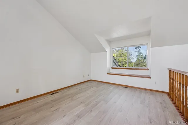 an empty room with wooden floor and window