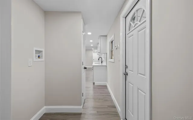 a view of a hallway with wooden floor and closet area