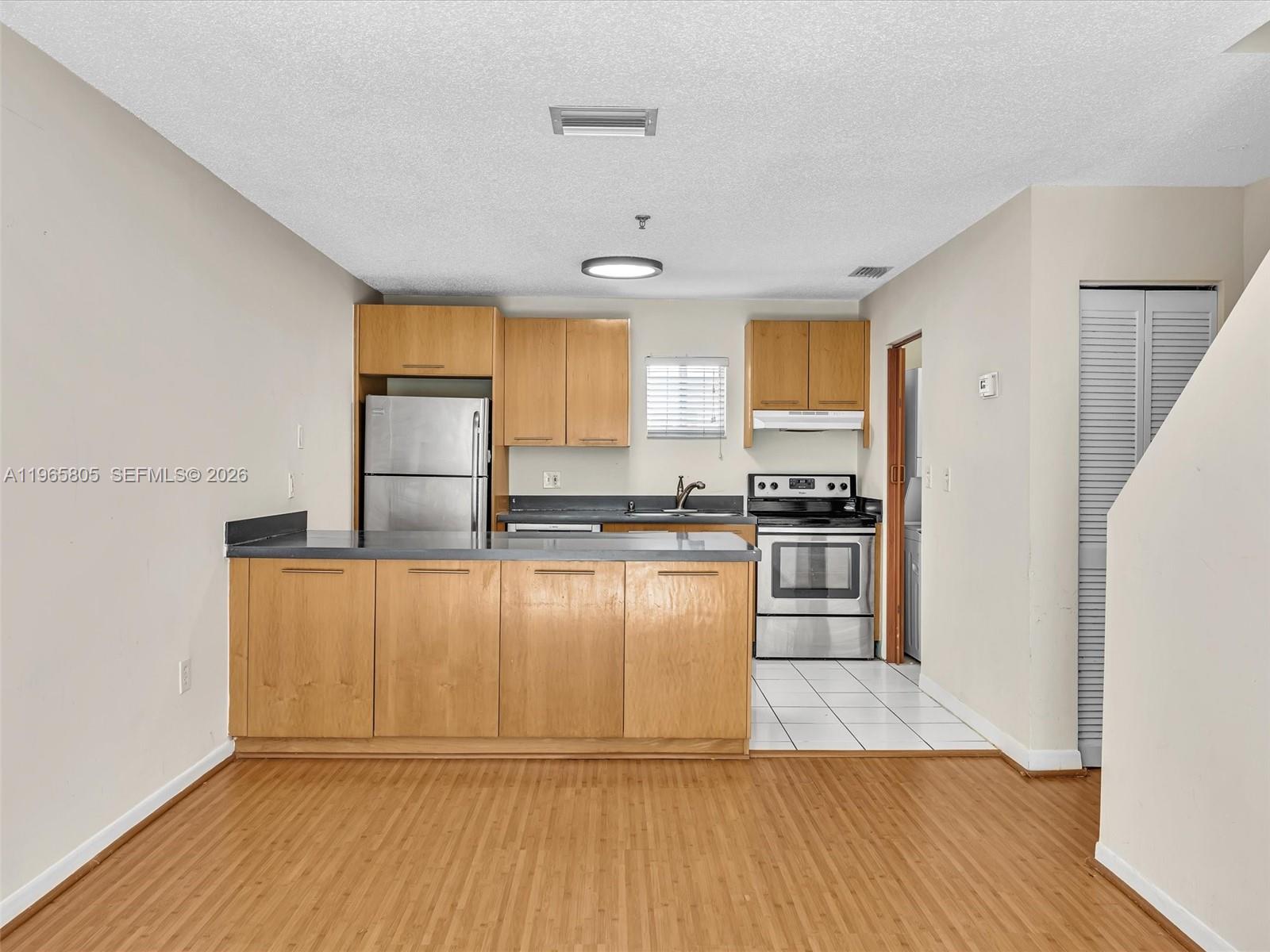 240 Southwest 15th Road, Unit 112 Miami, FL 33129 - Photo 23 of 47 a kitchen with granite countertop a stove top oven and cabinets