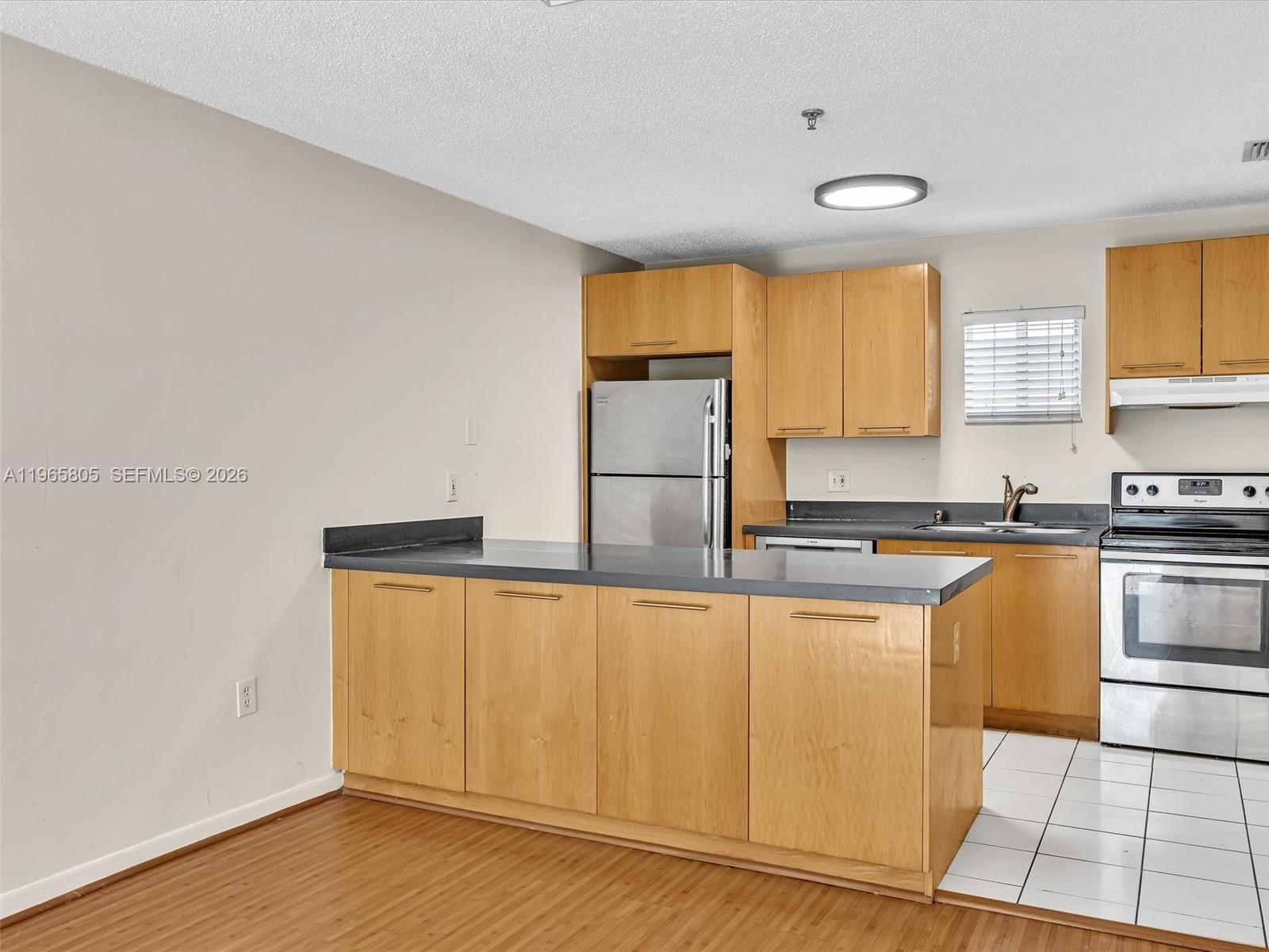 240 Southwest 15th Road, Unit 112 Miami, FL 33129 - Photo 24 of 47 a kitchen with stainless steel appliances granite countertop a sink and cabinets
