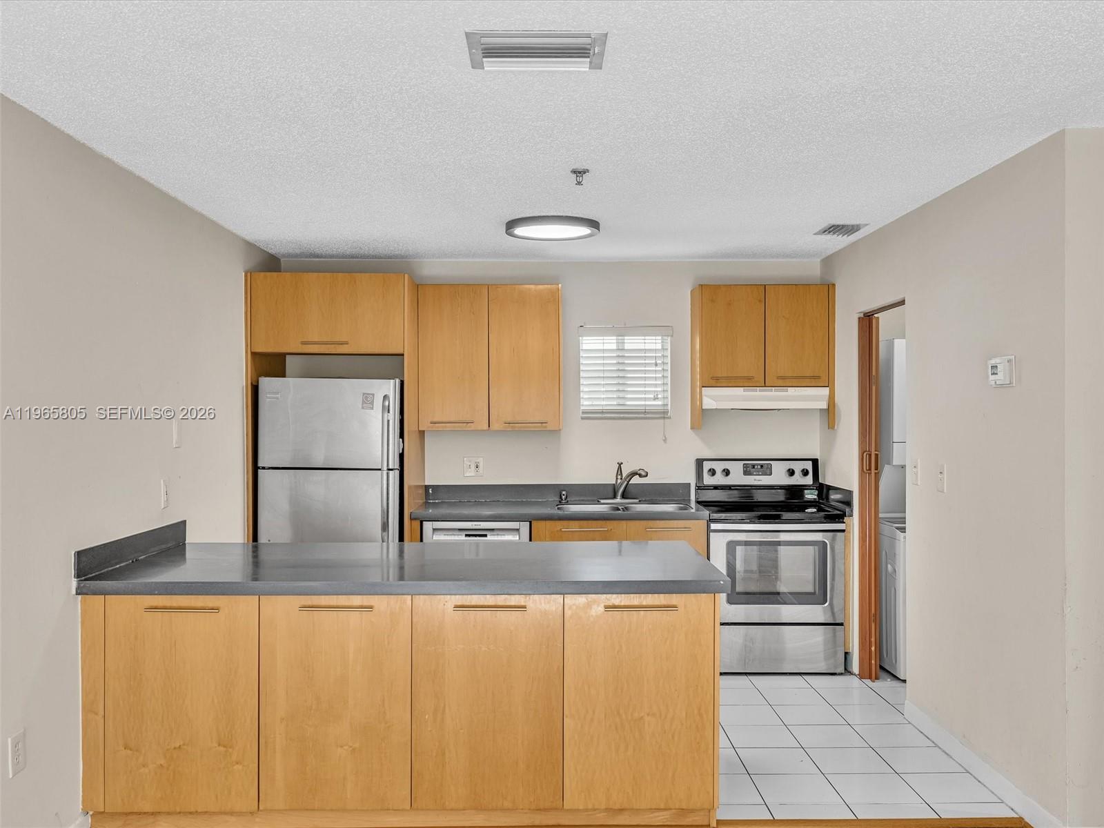 240 Southwest 15th Road, Unit 112 Miami, FL 33129 - Photo 26 of 47 a kitchen with stainless steel appliances granite countertop a stove a sink and a refrigerator