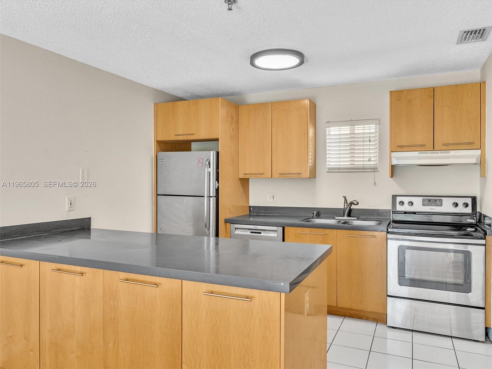 240 Southwest 15th Road, Unit 112 Miami, FL 33129 - Photo 3 of 47 a kitchen with a sink a stove and cabinets