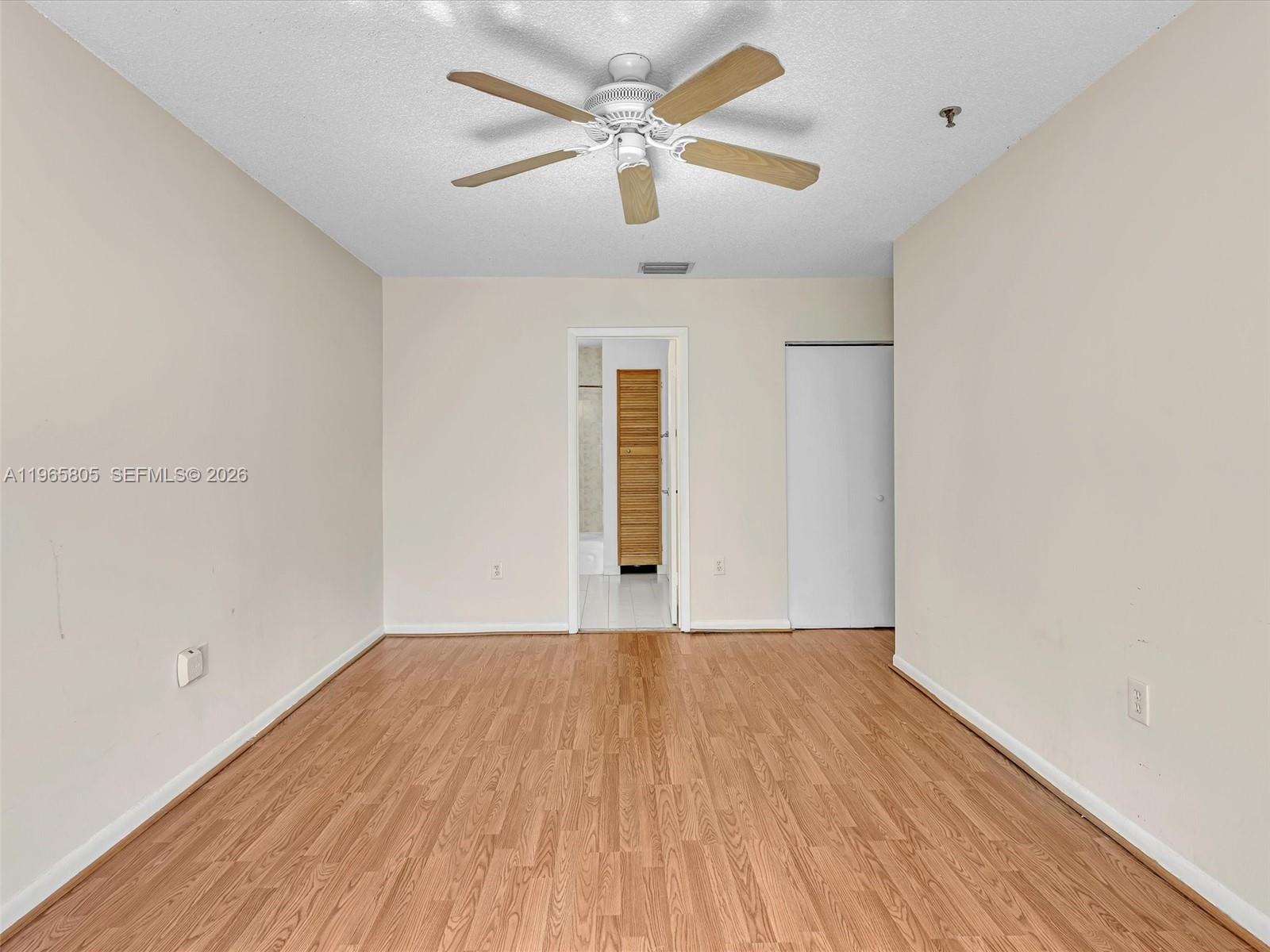 240 Southwest 15th Road, Unit 112 Miami, FL 33129 - Photo 36 of 47 an empty room with wooden floor ceiling fan and windows