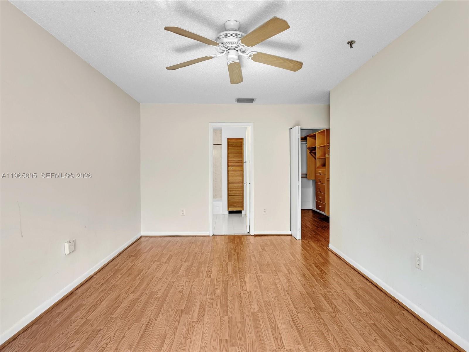 240 Southwest 15th Road, Unit 112 Miami, FL 33129 - Photo 37 of 47 an empty room with wooden floor ceiling fan and windows