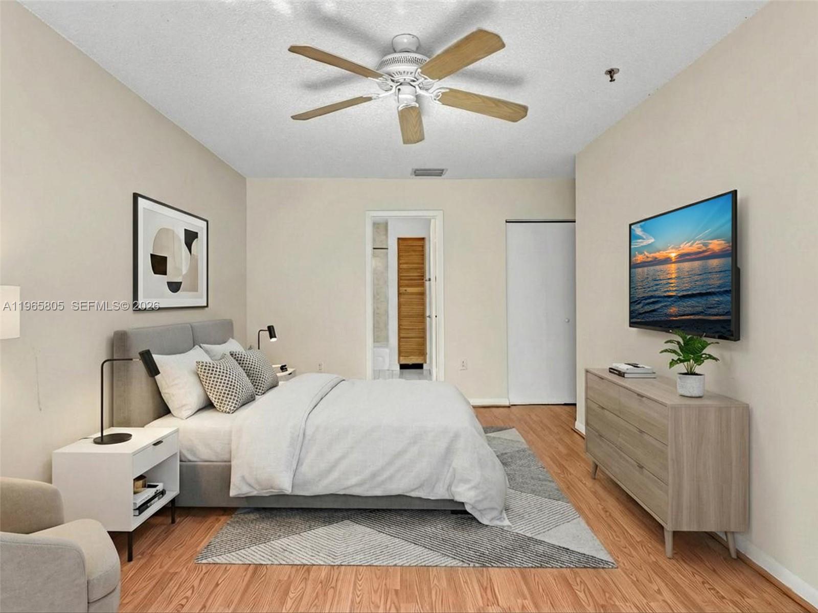240 Southwest 15th Road, Unit 112 Miami, FL 33129 - Photo 4 of 47 a bedroom with a large bed a flat tv screen and a ceiling fan