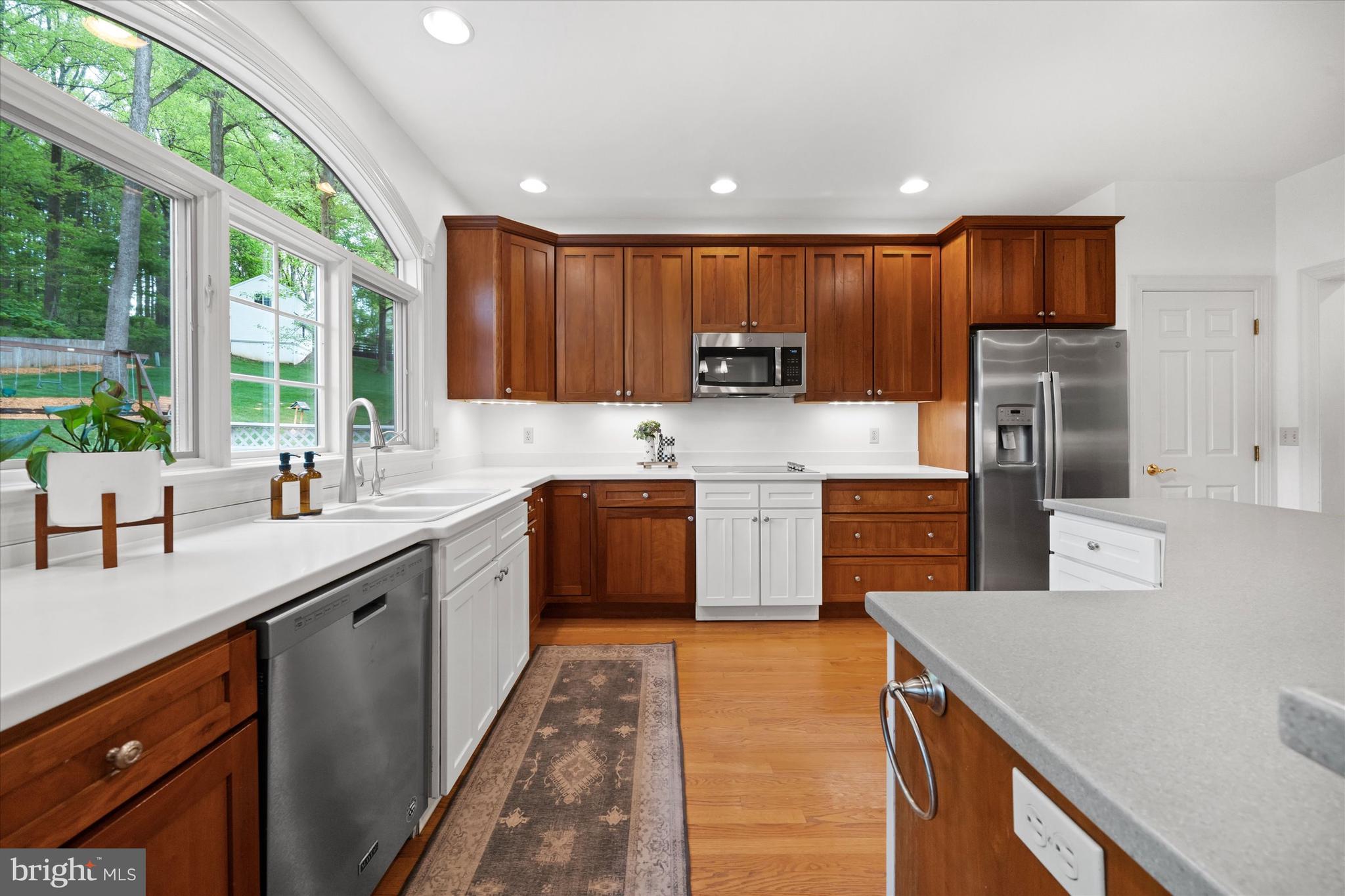 1618 Snuff Mill Road Hockessin, DE 19707 - Photo 13 of 48 a kitchen with a sink a counter top space stainless steel appliances a large window and cabinets