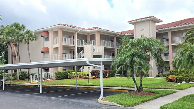 a front view of a building with a garden and plants
