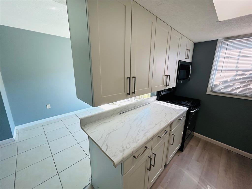 2785 L B McLeod Road, Unit B Orlando, FL 32805 - Photo 3 of 11 a bathroom with a granite countertop sink and a mirror