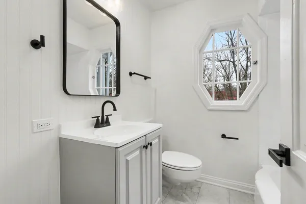 a bathroom with a toilet a sink and mirror