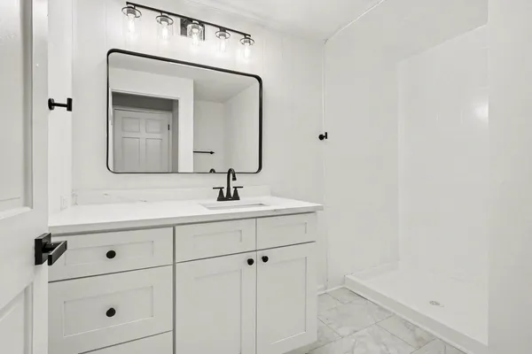 a bathroom with a sink vanity and mirror