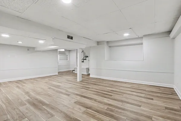 a view of empty room with wooden floor