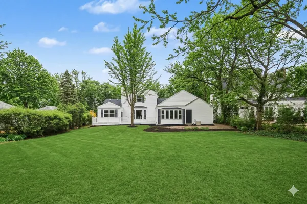 a front view of a house with a yard and trees