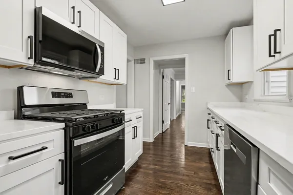 a kitchen with stainless steel appliances a stove microwave and sink