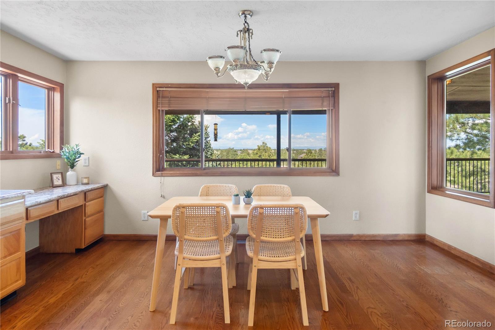 74 Rocky Cliff Road Elizabeth, CO 80107 - Photo 15 of 50 a dining room with wooden floor a chandelier a wooden table and chairs