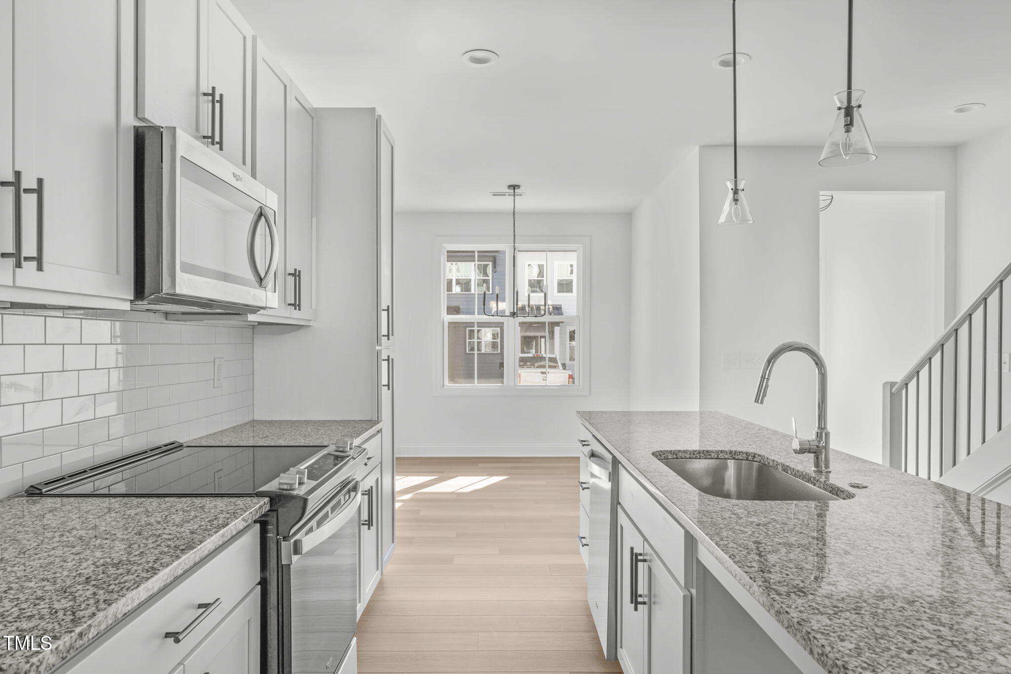 a kitchen with granite countertop a sink a stove and kitchen island